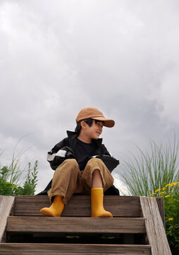 Chinese boy sits on wooden steps in the mountains
