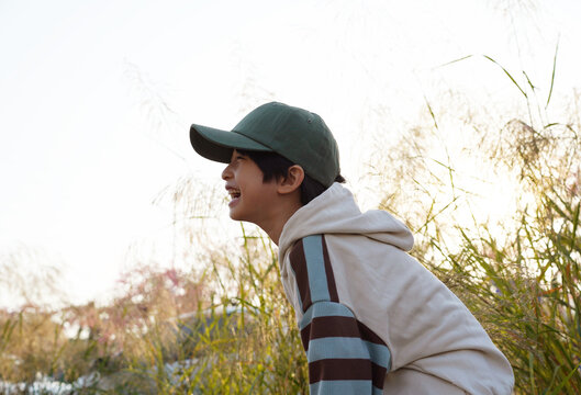 Chinese boy playing in the reeds outdoors