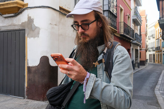 Man Using Phone Near Narrow Street