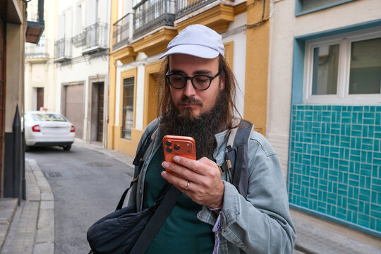 Man Using Phone on Narrow Street