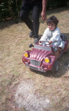 Little girl playing in pedal car