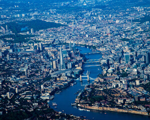 Fototapeta premium High-altitude aerial view of central London, England, showcasing the River Thames winding through the city with its dense urban skyline, historic landmarks, and modern business districts. The image ca