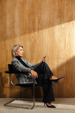 Person sitting in chair and looking at smartphone