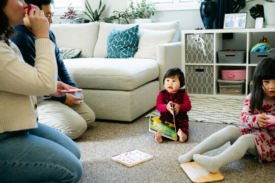 toddler in play area in her living room with parents