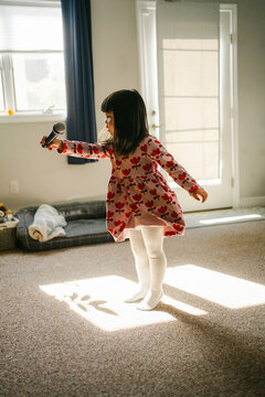 little girl  singing and dancing in living room 