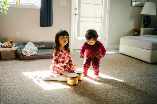 two little girls, sisters, singing and playing drums 