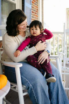 mother and her baby girl sitting on the porch 