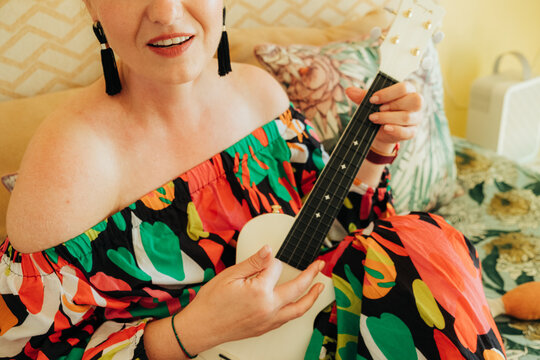 Close-up of woman holding ukulele indoors
