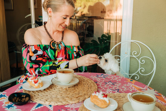 Woman and her dog during tea time at home