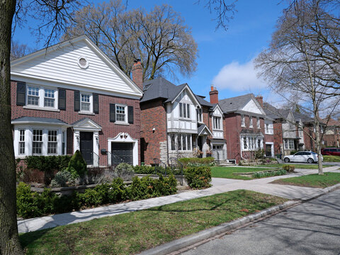Suburban residential street with traditional brick detached houses