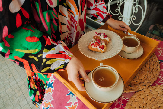 Close-up of tea cups and pastries on serving tray