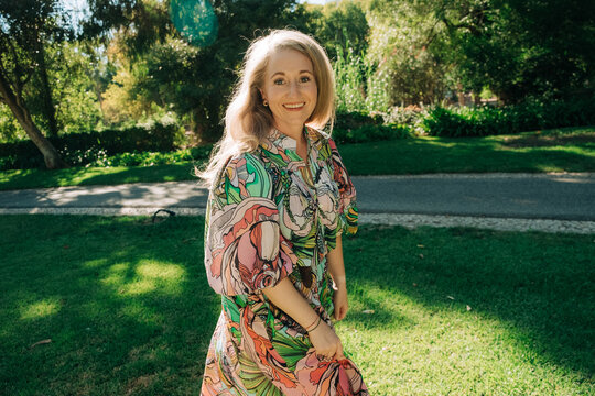 Smiling woman standing in green park landscape