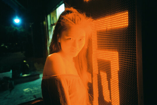 Horizontal Night Portrait of Woman Bathed in Intense Orange Neon Light