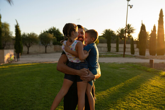 Father hugging his children