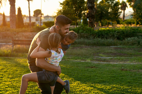 Father hugging his children
