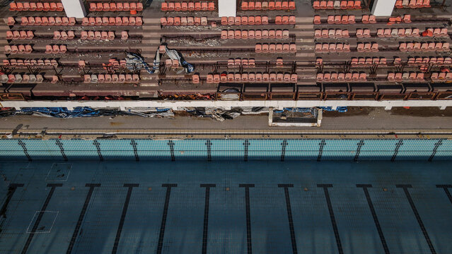Abandoned Swimming Pool and Damaged Stadium Seats