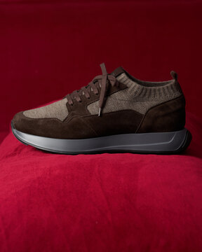 Brown sporty sneaker on red fabric background