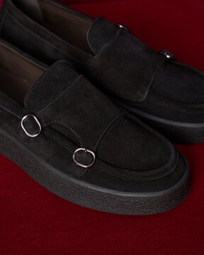 Footwear placed on a red surface with simple design