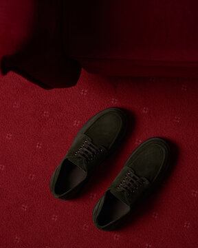 Green shoes on a red carpet in a cozy room setting