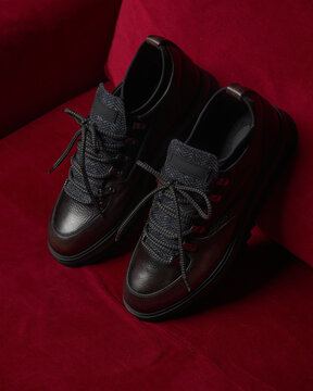 Black shoes on red background in a simple setup