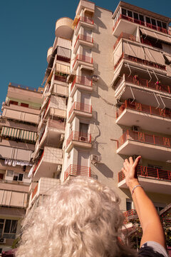 Woman Pointing at Building