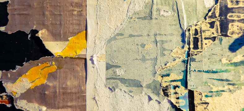 Old billboard with ripped torn posters background