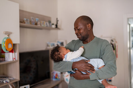 Man holding his sleeping infant with love and tenderness