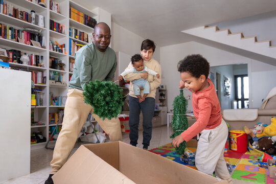 Family unboxing Christmas Tree for Holiday  in Living Room