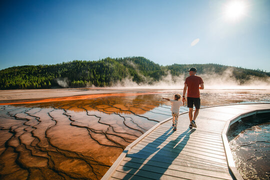 Father and daughter walking boardwalk at Midway Geyser Basin in Yellowstone National Park