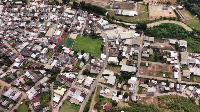 Aerial drone view of Alfredo Chaves city in Esp&iacute;rito Santo, Brazil. Urban area surrounded by green mountains, hills and rural landscape under blue sky, typical countryside scenery.