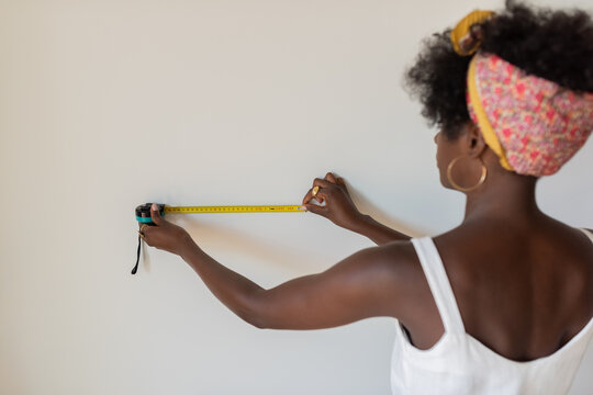Measuring Wall Length for a Home Improvement Project in a Bright Room