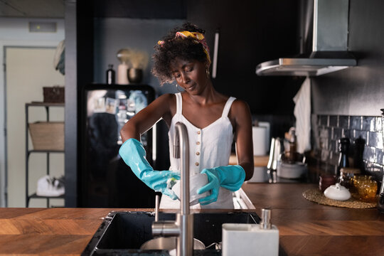 Smiling woman washing dishes at kitchen