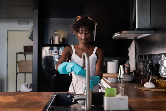Woman washing dishes in sink 