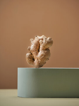 Fresh ginger root is placed on a light green block