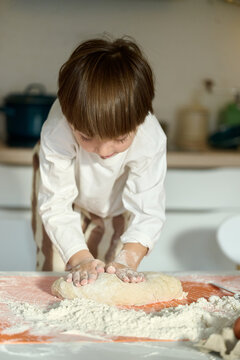 Child Kneading Dough at Home
