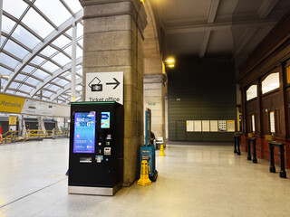 Obraz premium Ticket machine and ticket office in Manchester UK train station concourse with glass roof and modern interior