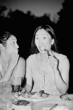 Friends sharing secret during meal