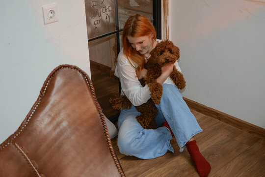 Portrait of a person with a pet poodle in a home setting