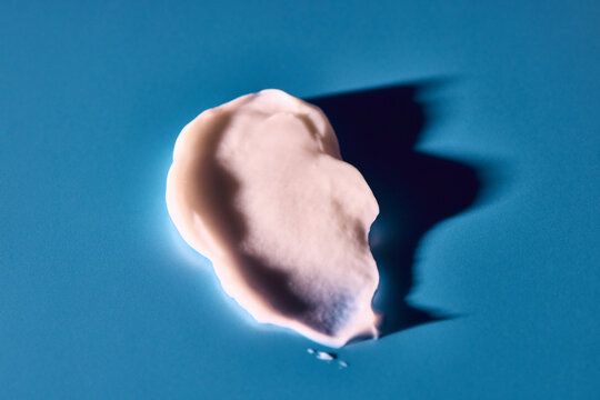 skincare lotion smear over cyan background