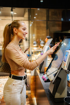 Woman ordering food at self-service kiosk in Vienna