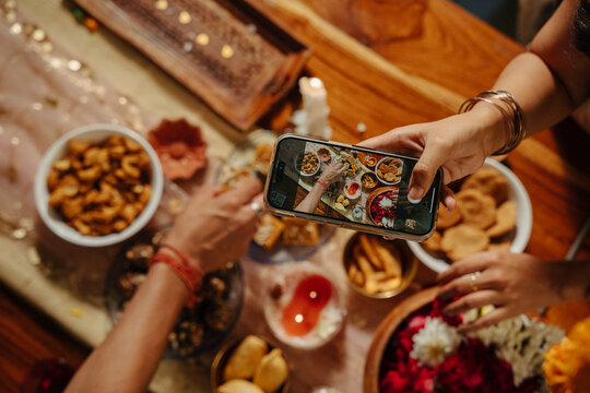 People Sharing Food and Taking Pictures at a Diwali Gathering