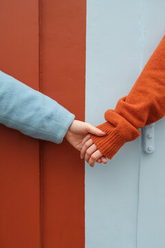 Hands Holding Across Wall