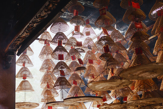 Dense Hanging Spiral Incense Coils with Red Tags in Temple