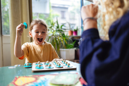 Joyful Child Playing Board Game With Family At Home