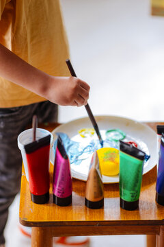 Child Painting With Colorful Paints And Palette