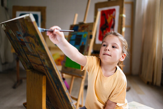 Boy Painting At Easel In Studio