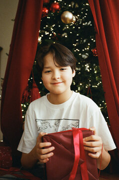 Smiling boy holding Christmas gift box
