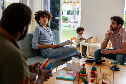 Family therapy session with child playing in background.