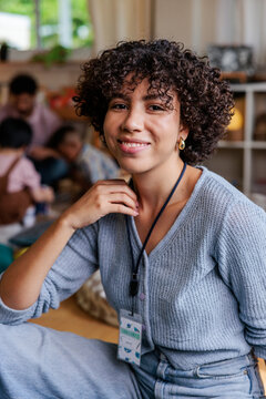 Smiling woman with curly hair wearing a name tag.