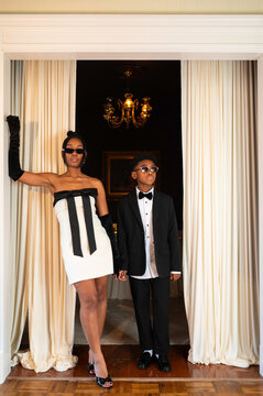 Mom and Son in Stylish Outfits Stand in a Beautiful Entryway